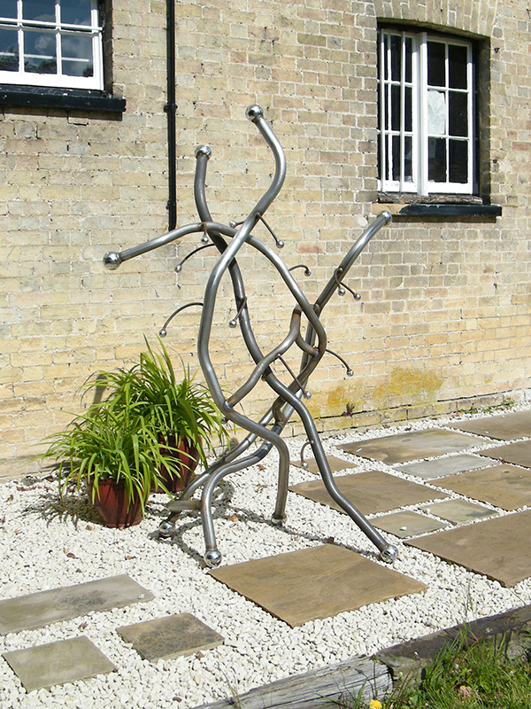 Metal sculpture titled Contorta viewed on patio
