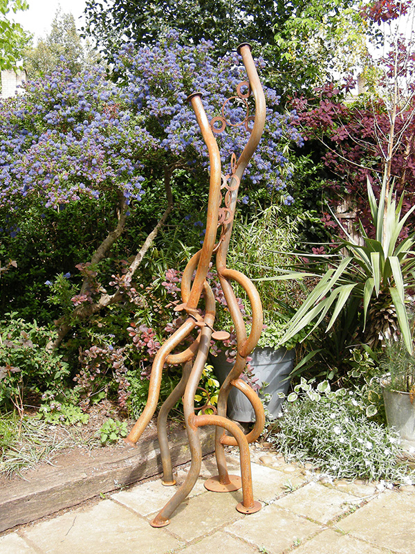 Serpentine sculpture viewed in artist's garden
